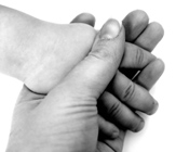 Picture of an adult&apos;s hand holding a little child&apos;s hand